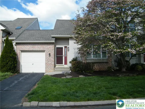 a front view of a house with a garden and yard