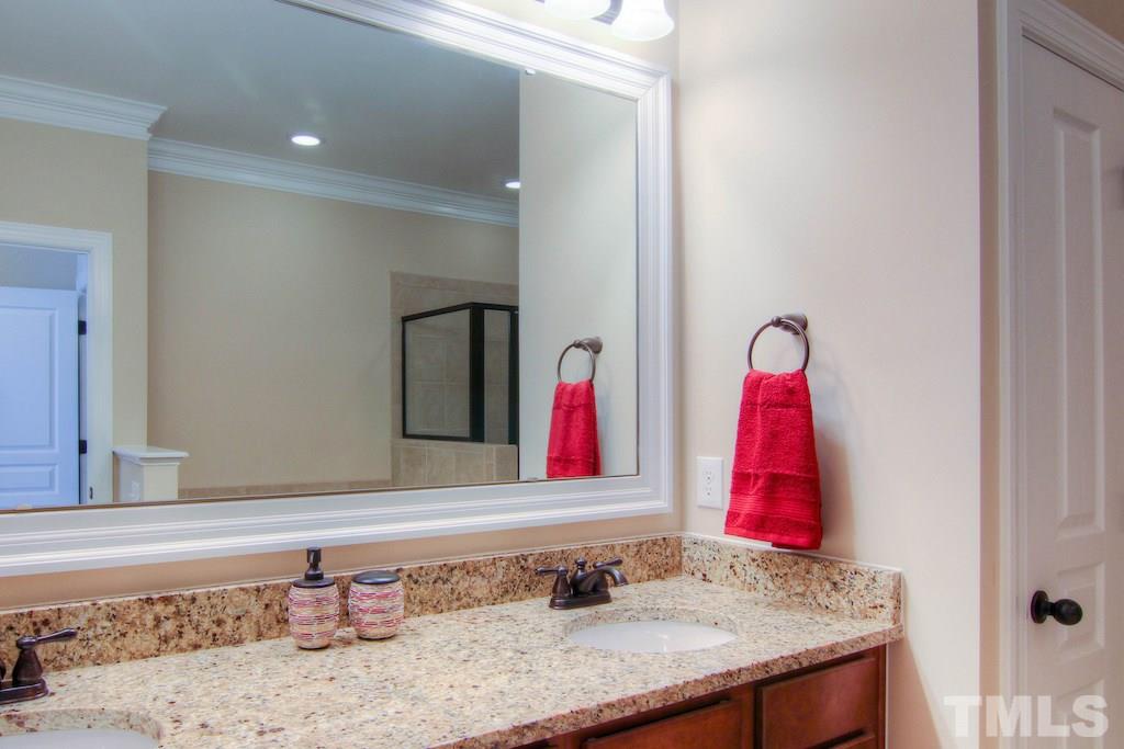 605 Democracy Street Raleigh, NC 27603 - Photo 13 of 25 a bathroom with a granite countertop sink and a mirror