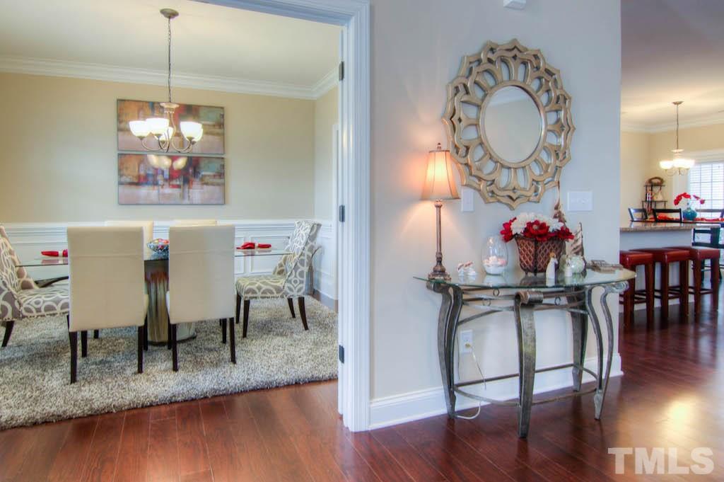 605 Democracy Street Raleigh, NC 27603 - Photo 4 of 25 a view of a dining room with furniture a chandelier and wooden floor