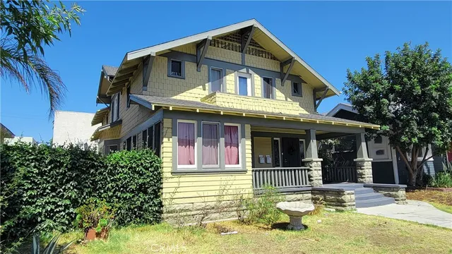 a view of a white house with large windows and a small yard