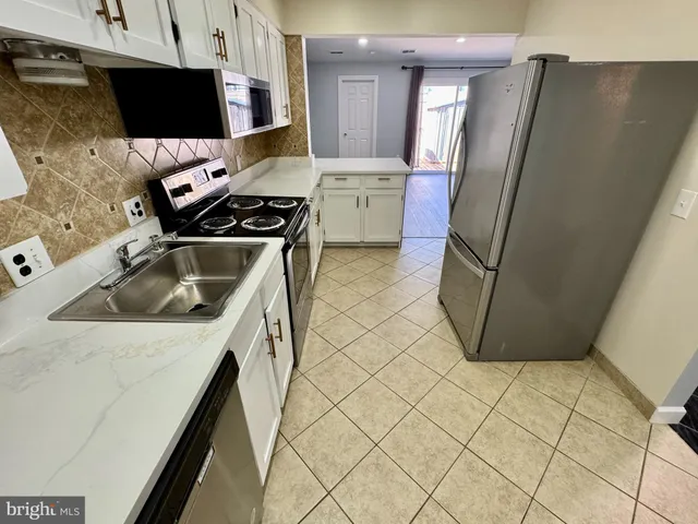 a kitchen with a sink a refrigerator and a stove