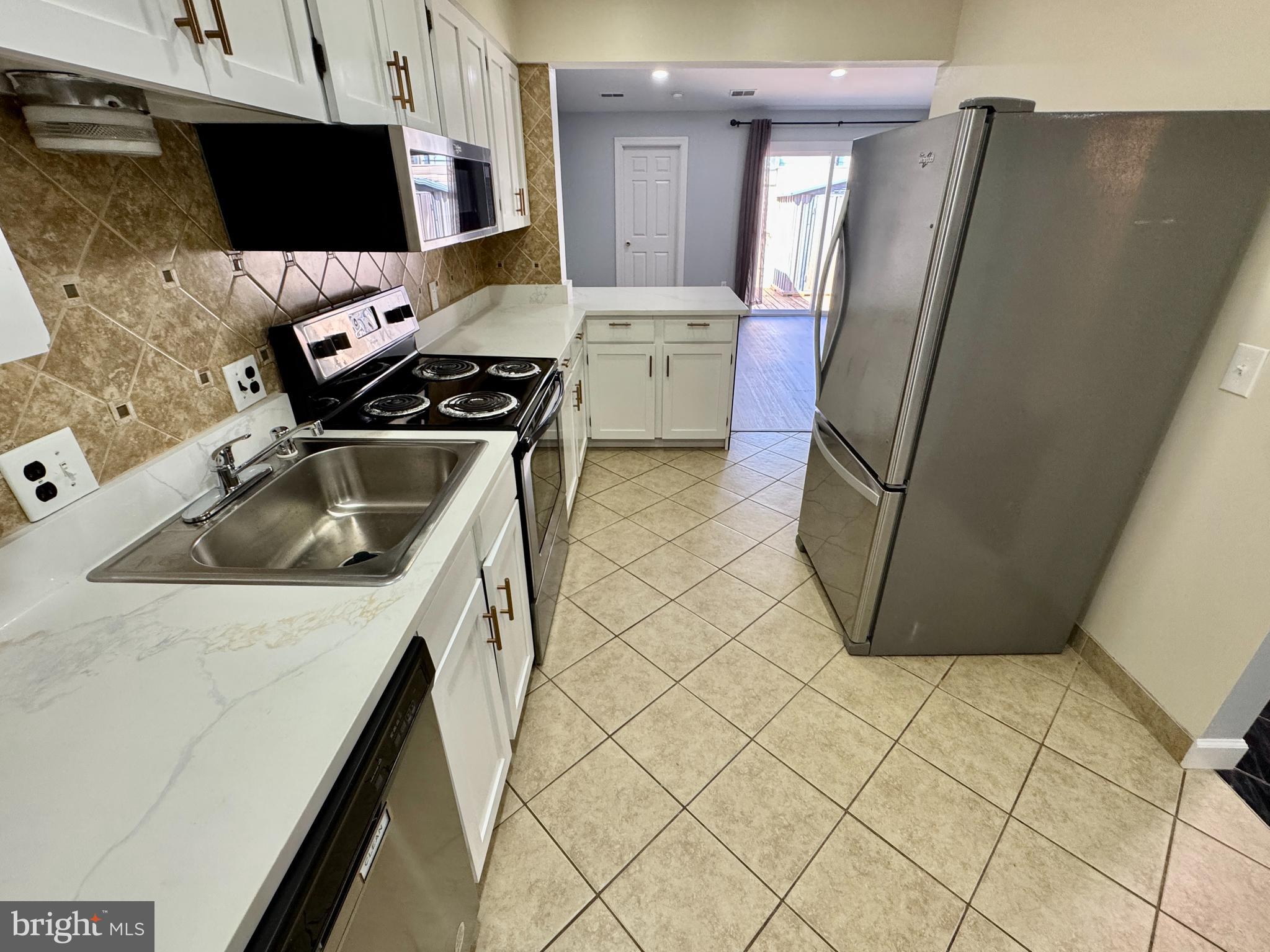 3664 Tavern Way Triangle, VA 22172 - Photo 11 of 28 a kitchen with a sink a refrigerator and a stove
