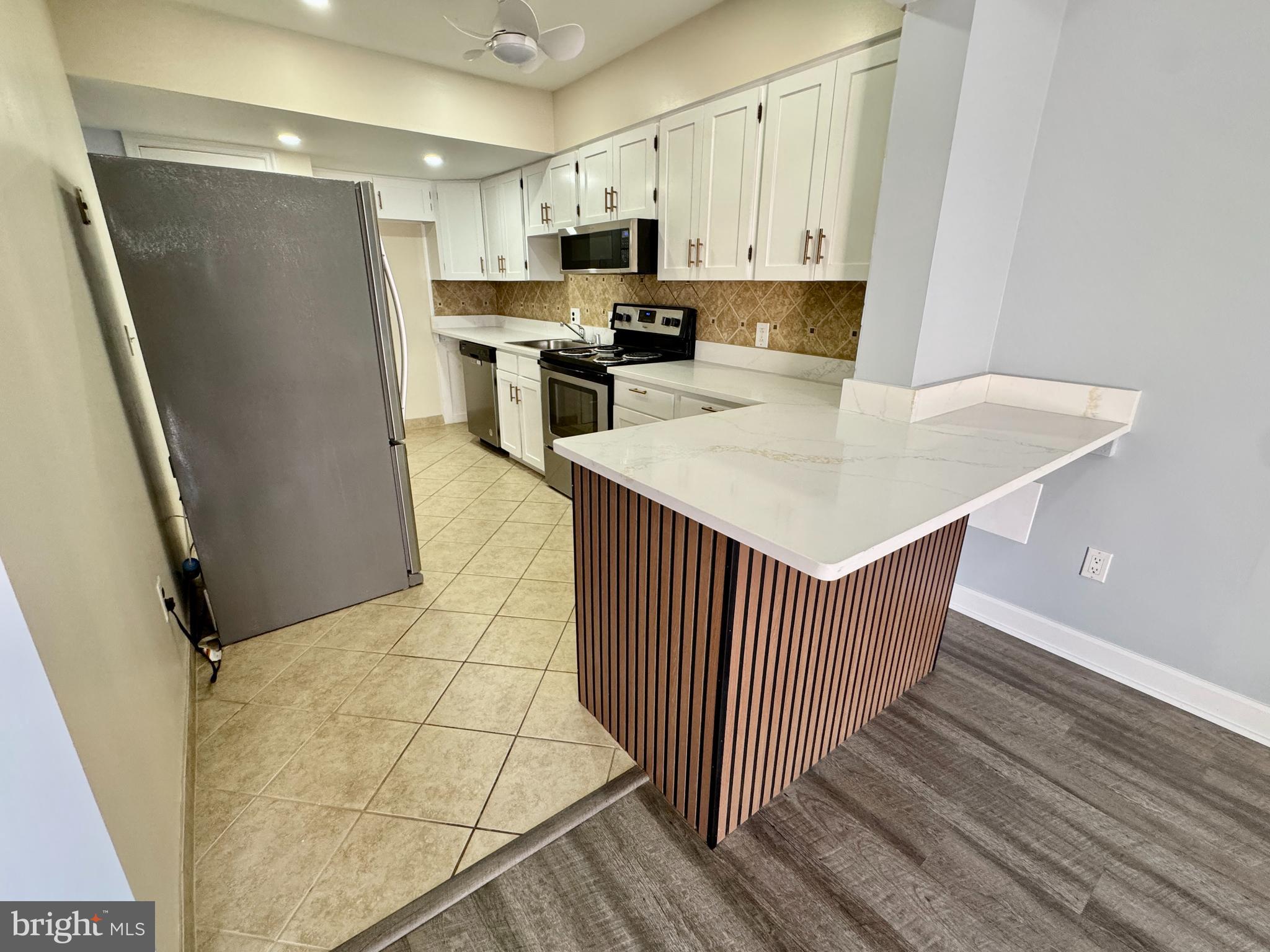 3664 Tavern Way Triangle, VA 22172 - Photo 12 of 28 a kitchen with stainless steel appliances a white refrigerator a stove a sink and white cabinets
