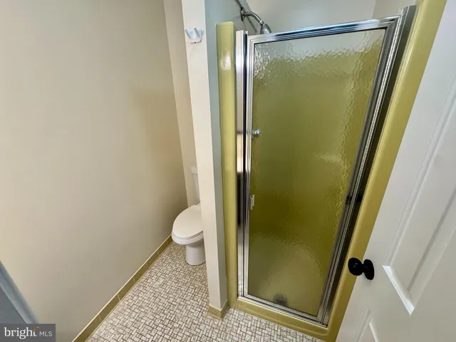 a bathroom with a granite countertop shower and a toilet