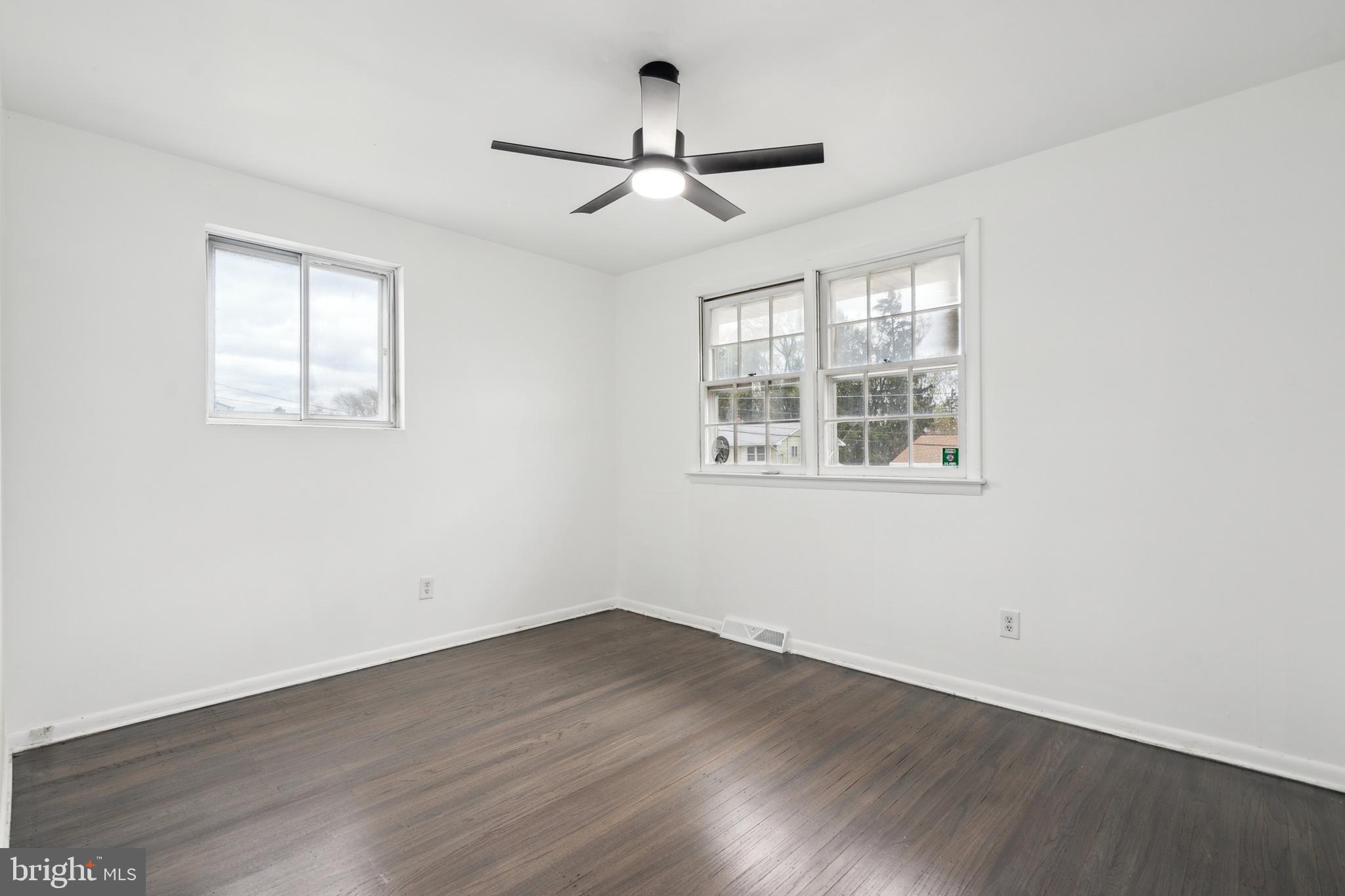306 Colonial Road Edgewater Park, NJ 08010 - Photo 17 of 25 an empty room with wooden floor ceiling fan and windows