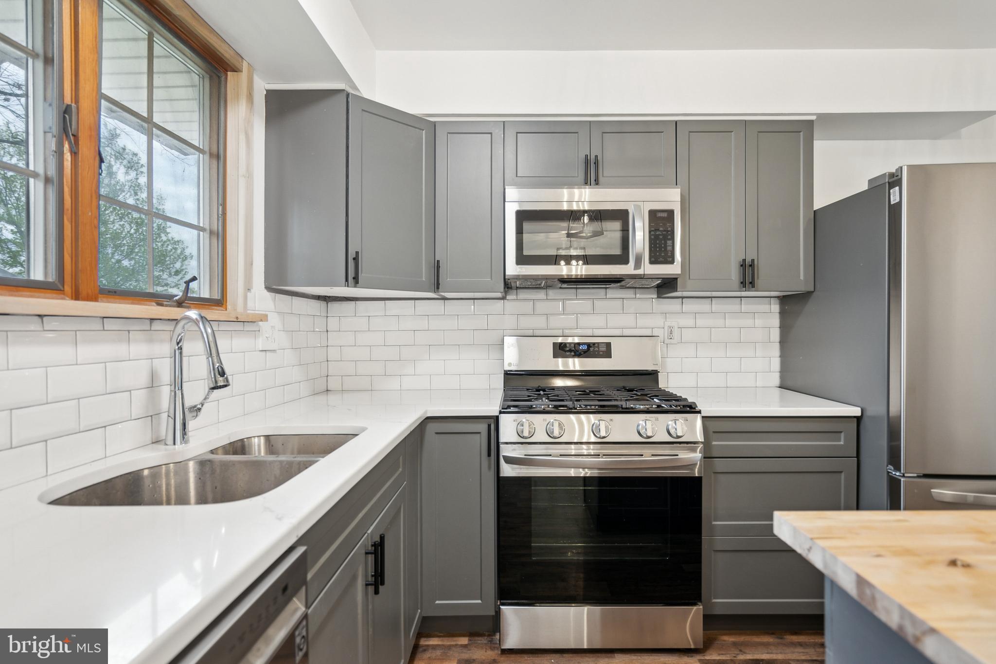 306 Colonial Road Edgewater Park, NJ 08010 - Photo 10 of 25 a kitchen with a sink stove and microwave