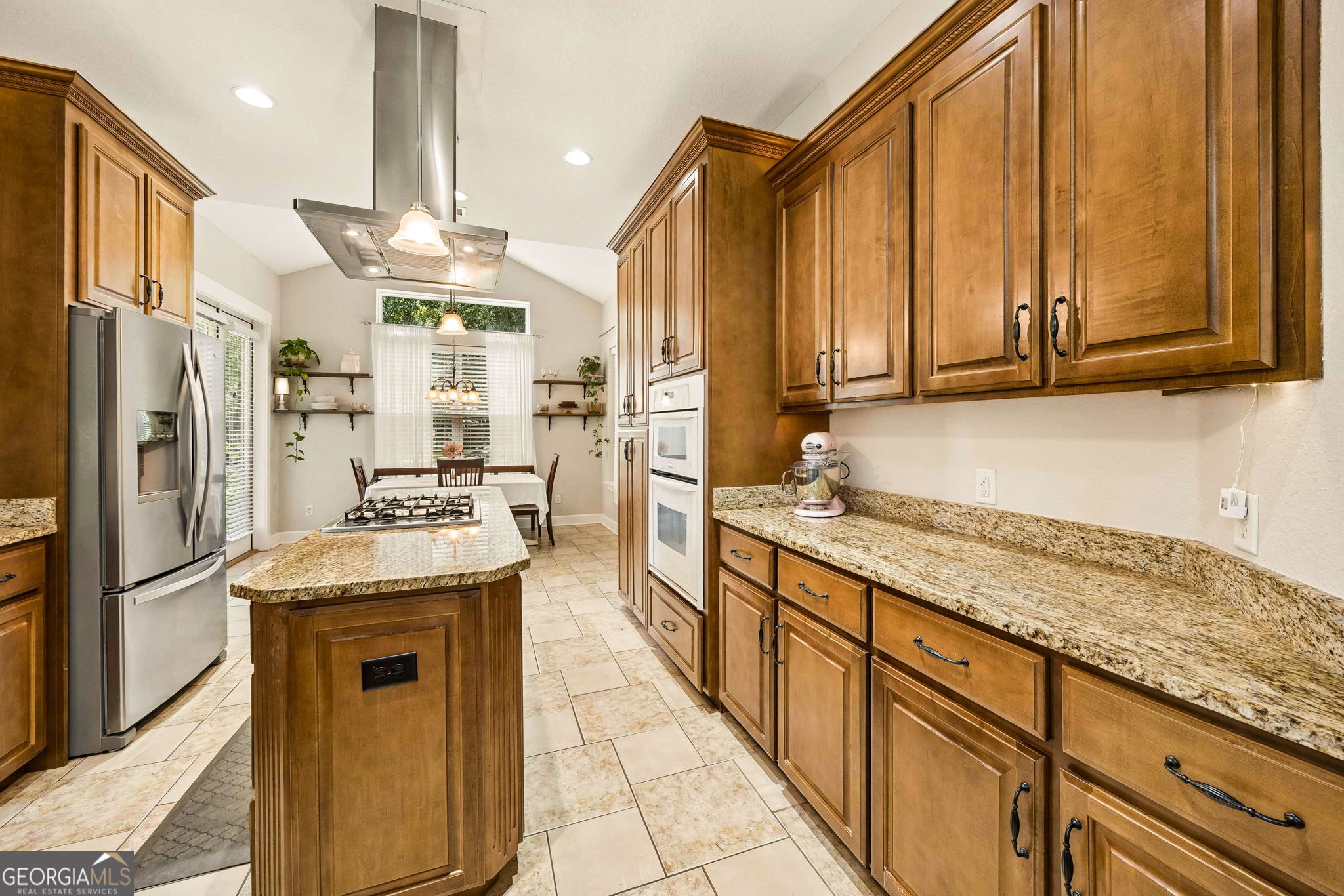 706 Hopewell Point Road White Oak, GA 31568 - Photo 17 of 84 Designed for both function and style, this gourmet kitchen features granite countertops, custom cabinetry, a large center island, and a gas cooktop beneath a statement stainless vent hood.