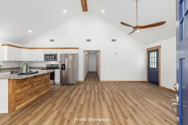 a kitchen with stainless steel appliances granite countertop a refrigerator and a stove top oven