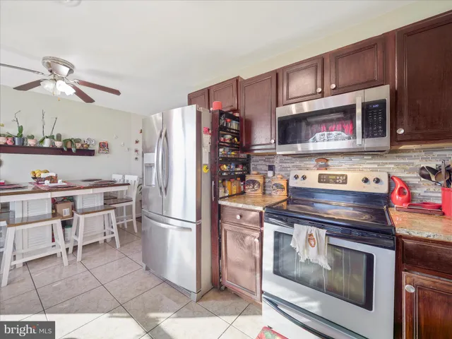 a kitchen with stainless steel appliances granite countertop a stove refrigerator and cabinets