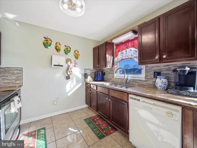 a kitchen with granite countertop a sink stainless steel appliances and cabinets