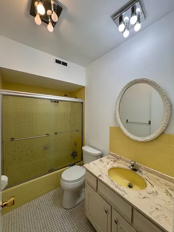 a bathroom with a granite countertop toilet a sink and mirror