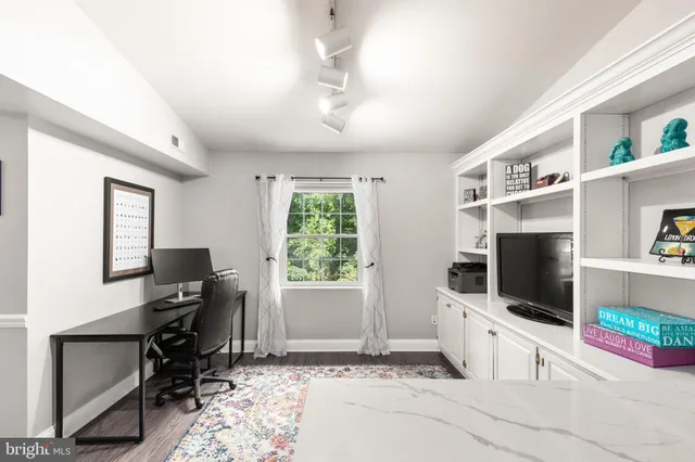 a hallway with white cabinets and flat screen tv