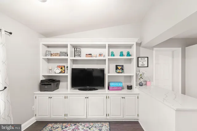 a kitchen with cabinets and wooden floor