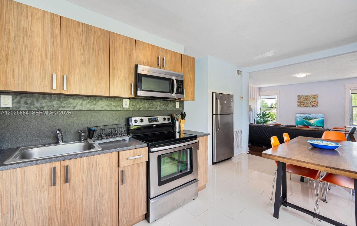2255 Southwest 10th Street, Unit B Miami, FL 33135 - Photo 17 of 26 a kitchen with stainless steel appliances a stove refrigerator sink and microwave