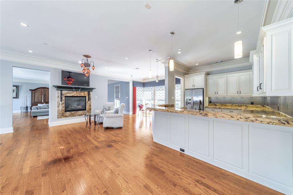 4511 Watauga Road Dallas, TX 75209 - Photo 24 of 40 a view of a kitchen with kitchen island a sink wooden floor and a fireplace