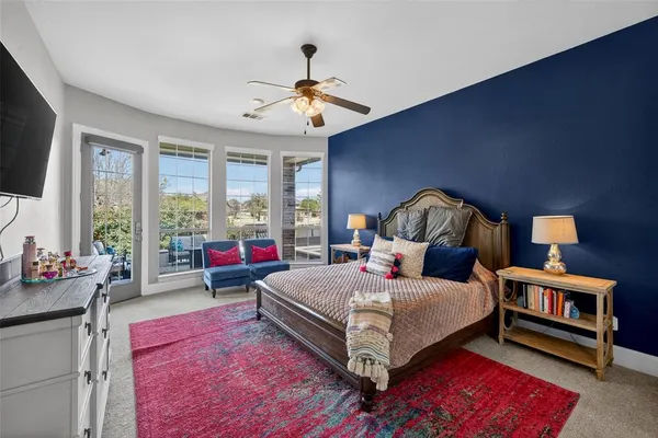 a bedroom with a bed a rug and potted plant on dresser