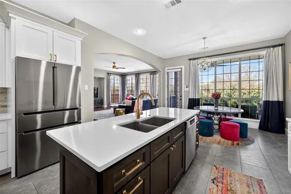 a kitchen that has a sink refrigerator and dining table