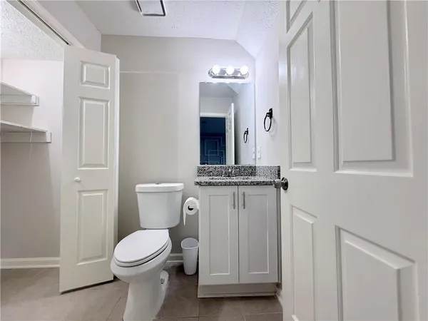 a bathroom with a toilet a sink and mirror