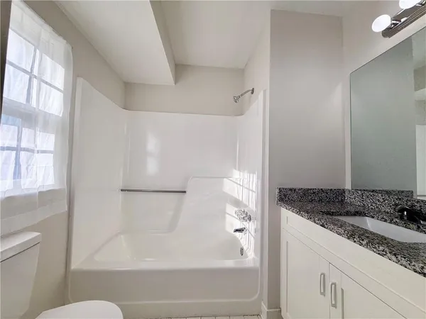a bathroom with a granite countertop sink toilet and shower