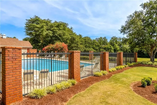 a view of a swimming pool with lawn chairs under an umbrella