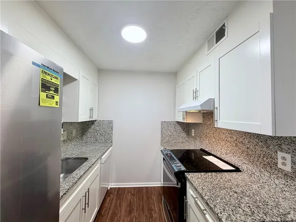 a kitchen with granite countertop a stove and a sink