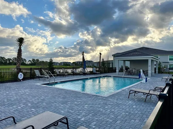 a view of a house with swimming pool and sitting area