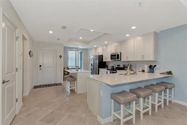 a kitchen with a sink and chairs
