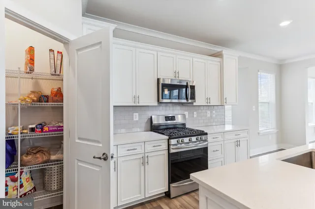 a kitchen with white cabinets and appliances