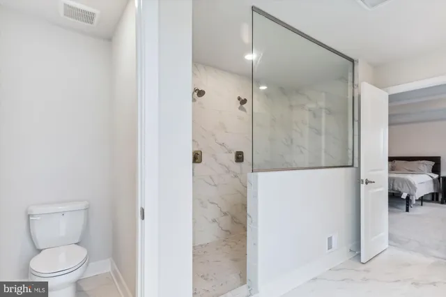 a bathroom with a toilet and a shower