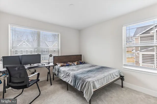 a bedroom that has a bed chair and a computer on a desk
