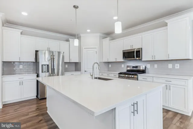 a kitchen with stainless steel appliances a stove refrigerator sink and microwave