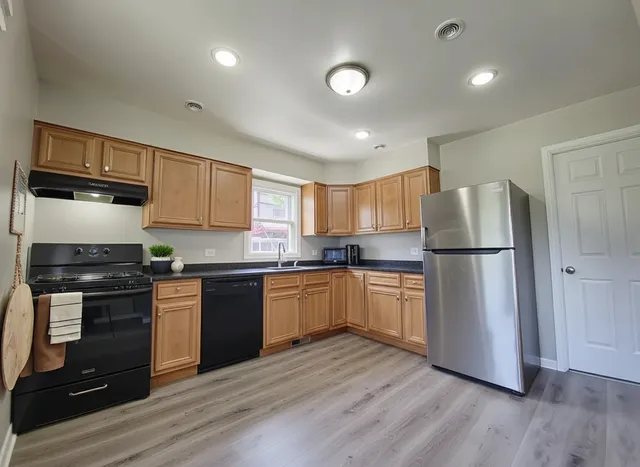 a kitchen with a refrigerator stove and wooden cabinets