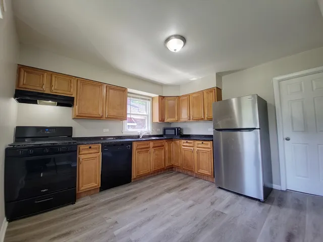 a kitchen with a refrigerator stove and wooden cabinets