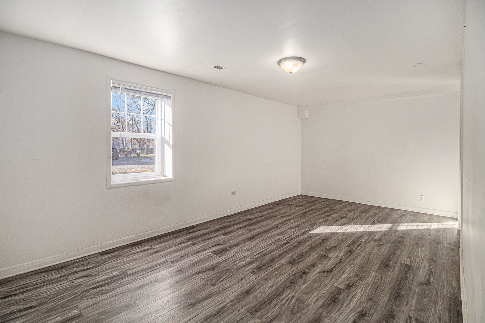 2036 Thornton Lansing Road Lansing, IL 60438 - Photo 10 of 17 a view of an empty room with wooden floor and a window
