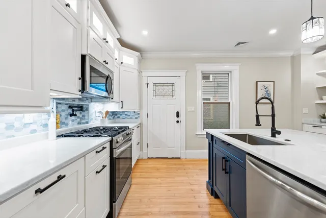 a kitchen with stainless steel appliances granite countertop a sink stove and cabinets