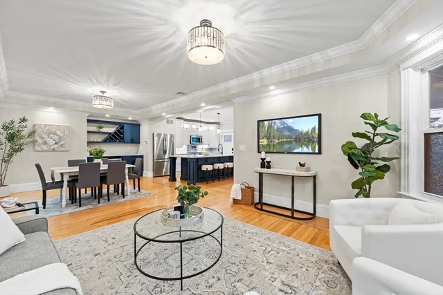 a living room with furniture a dining table and a chandelier