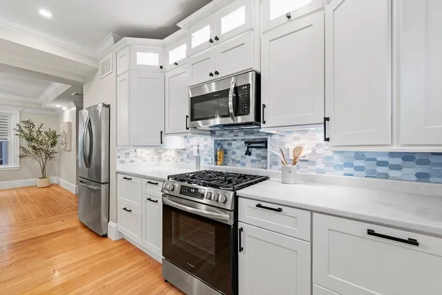 a kitchen with stainless steel appliances white cabinets stove and refrigerator