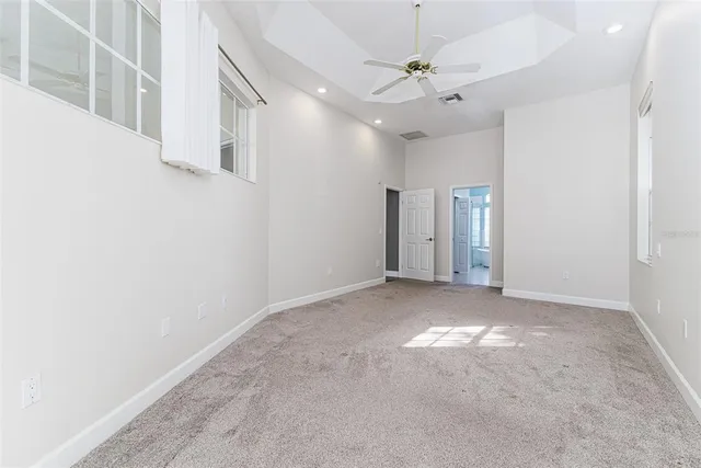 en empty room with windows and ceiling fan