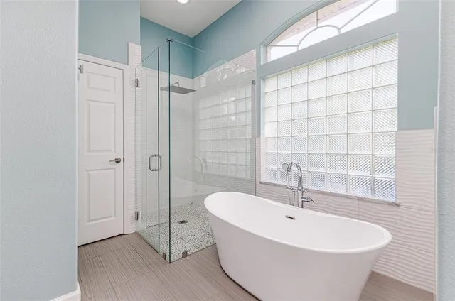 a white bath tub sitting next to a shower