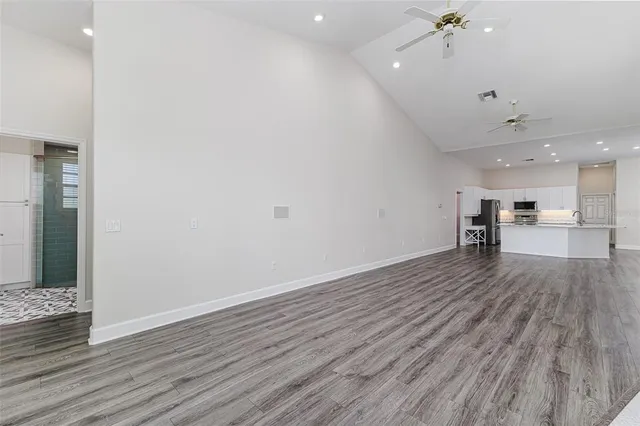 a view of a room with wooden floor and a kitchen