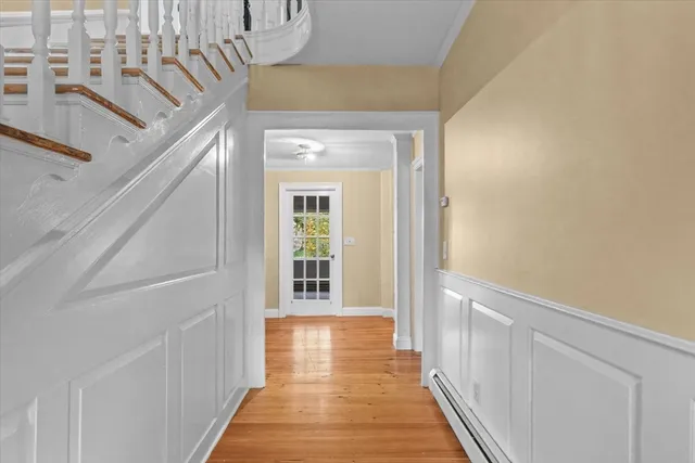 a view of a hallway with wooden floor and staircase