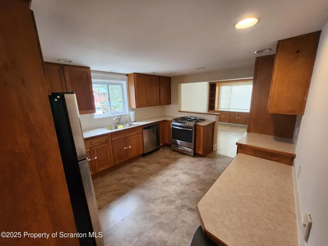 a living room with stainless steel appliances furniture and a window
