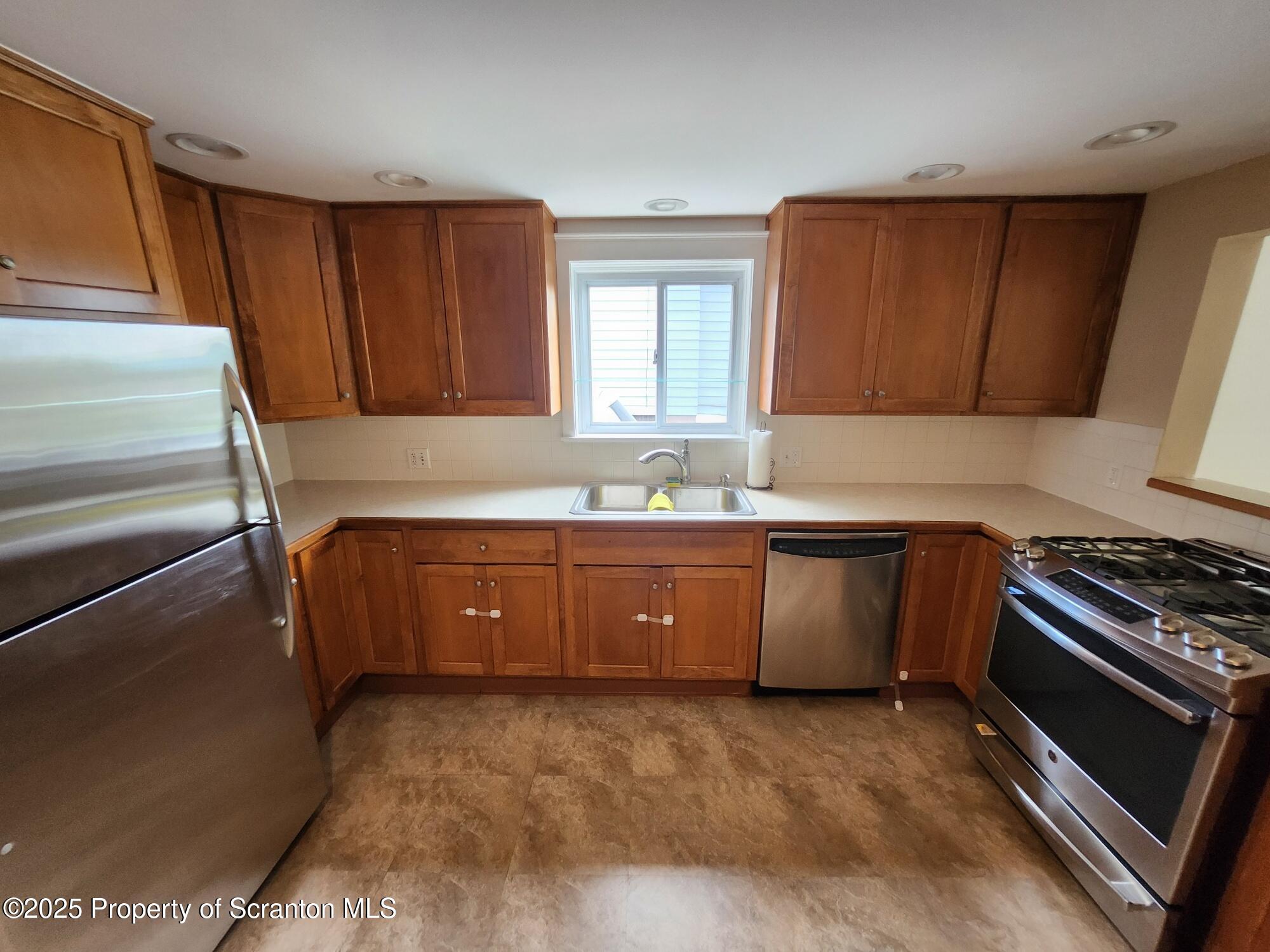 16 Flanagan Street Pringle, PA 18704 - Photo 17 of 33 a kitchen with granite countertop a sink cabinets and stainless steel appliances