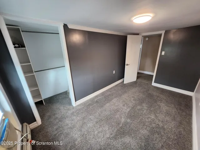 an empty room with windows and mirror