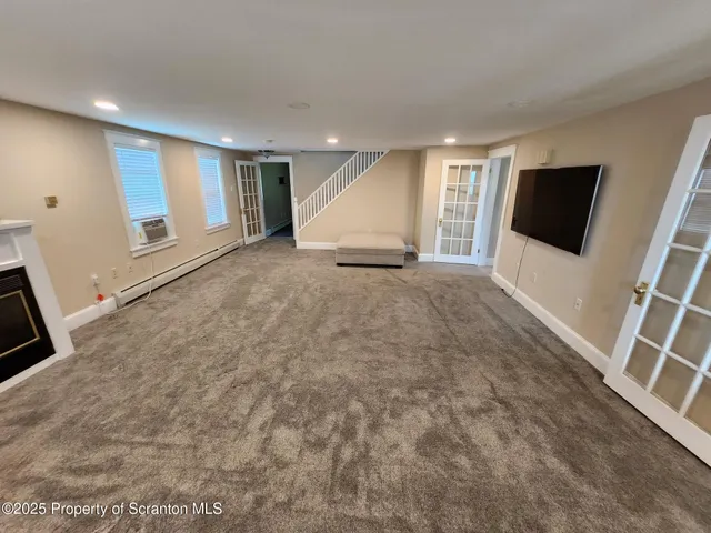 a view of a livingroom with entryway and a window