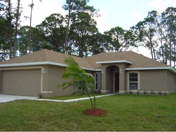 1786 Northwest Rangoon Palm Bay, FL 32907 - Photo 1 of 11 a front view of a house with a garden and yard
