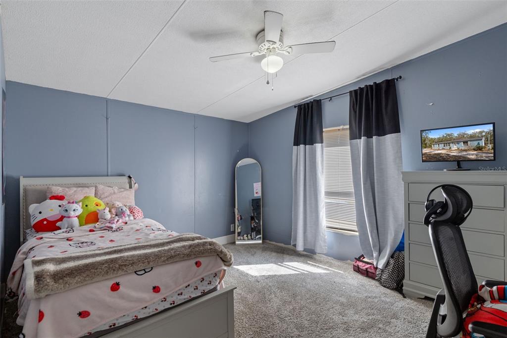 11881 Southwest 45th Street Webster, FL 33597 - Photo 16 of 27 a bedroom with a bed and a chandelier