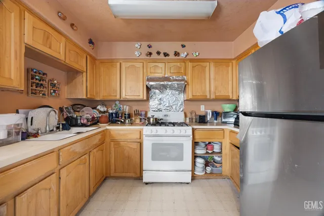 a kitchen with stainless steel appliances granite countertop a sink and a refrigerator