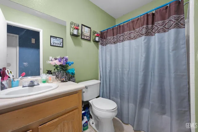 a bathroom with a sink a toilet and shower curtain