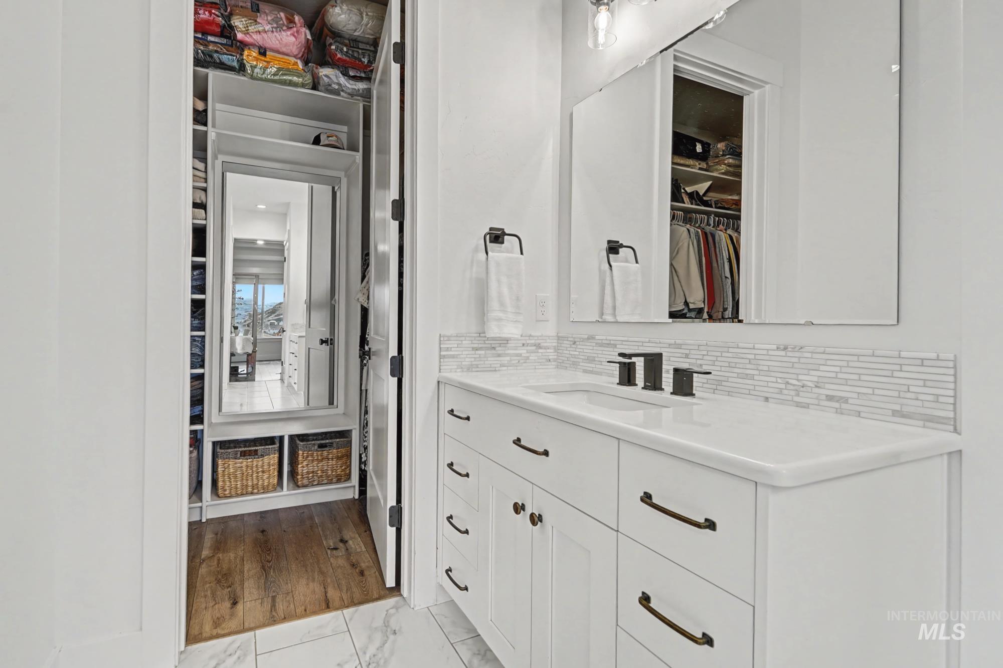 18357 North Burnt Car Way Boise, ID 83714 - Photo 28 of 48 Bathroom with a spacious closet, vanity, light marble finish floors, and decorative backsplash
